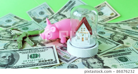 Piggy bank, toy house and keys on the background of dollar bills, the concept of material values, buying a house, developing finance Piggy bank, toy house and keys on the background of dollar bills, the concept of material values, buying a house, developing finance 86876232
