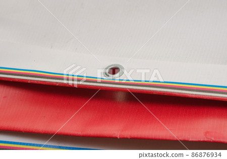 A red and white billboard. PVC fabric folded. Banner with eyelets. Selective focus. 86876934