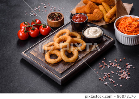 Homemade crunchy fried onion rings with tomato sauce 86878170