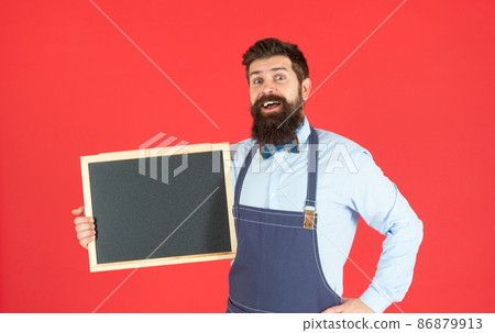 Surprised bearded man hold school blackboard red background copy space, promotional advertising 86879913