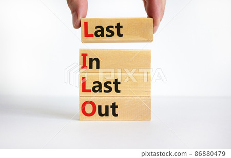LILO last in last out symbol. Concept words LILO last in last out on wooden blocks. Beautiful white table white background. Businessman hand. Business and LILO last in and out concept. Copy space. 86880479