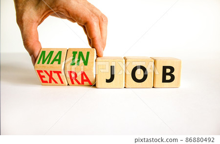 Extra or main job symbol. Businessman turns wooden cubes and changes concept words Extra job to Main job. Beautiful white table white background, copy space. Business extra or main job concept. 86880492