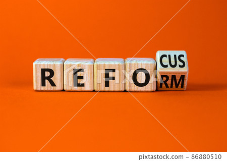 Refocus and reform symbol. Turned a wooden cube and changed the word refocus to reform. Beautiful orange table, orange background. Business refocus and reform concept. Copy space. Refocus and reform symbol. Turned a wooden cube and changed the word refocus to reform. Beautiful orange table, orange background. Business refocus and reform concept. Copy space. 86880510