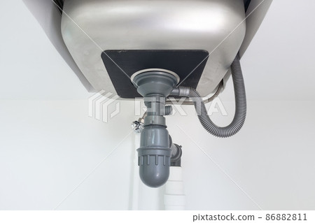 Drain pipe or sewer under kitchen sink in drainage system. 86882811