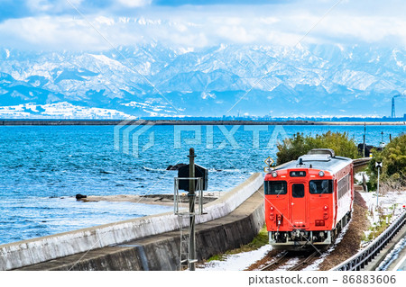 Toyama Prefecture Winter Himi Line (Amaharashi Coast) -Diesel train running with the Tateyama mountain range in the background- Toyama Prefecture Winter Himi Line (Amaharashi Coast) -Diesel train running with the Tateyama mountain range in the background- 86883606
