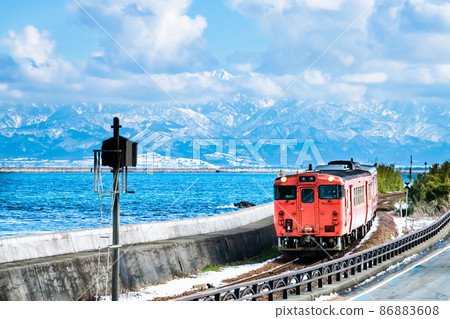 富山縣冬季冰見線（天晴海岸）～以立山山脈為背景的柴油列車～ 86883608