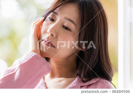 A sick woman in a loungewear bathed in the morning light A sick woman in a loungewear bathed in the morning light 86884500