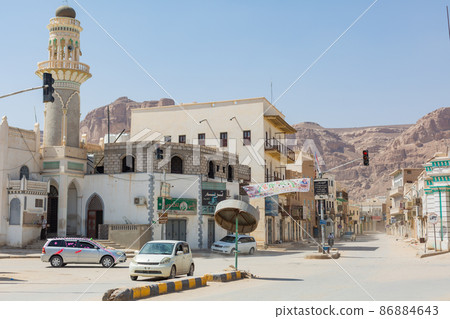 [也門] Hadramawt，一輛穿越寧靜的塔利姆城市景觀和十字路口的汽車 86884643