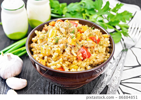 Barley porridge with minced meat in bowl on dark board 86884851
