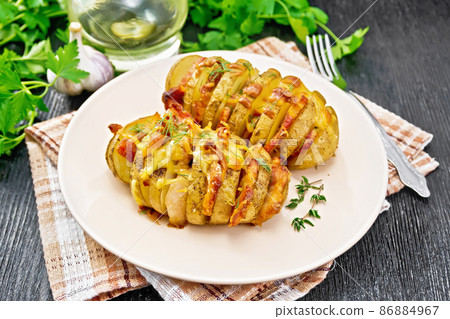 Potatoes with smoked bacon in plate on wooden board Potatoes with smoked bacon in plate on wooden board 86884967