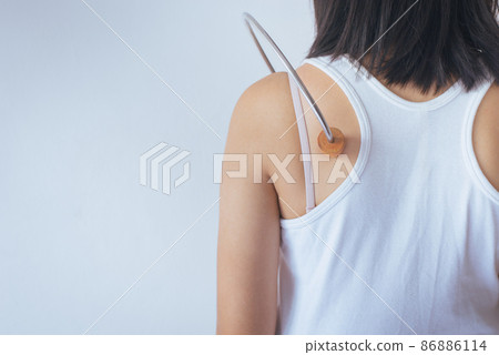 Woman using wood stick massage with her back 86886114