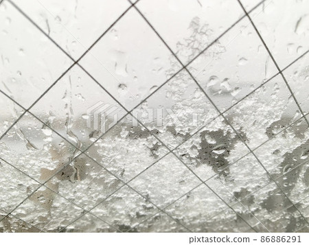 夾絲玻璃窗上的水滴和雪照片素材 夾絲玻璃窗上的水滴和雪照片素材 86886291