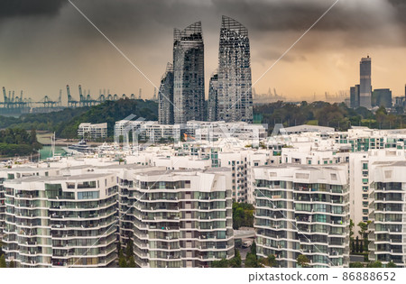 Top of real estate housing in down town of Singapore, few skyscrapers on background, storm sky at sunset Top of real estate housing in down town of Singapore, few skyscrapers on background, storm sky at sunset 86888652