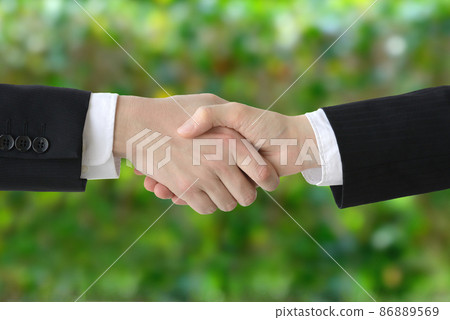 Handshake businessmen-green background Handshake businessmen-green background 86889569