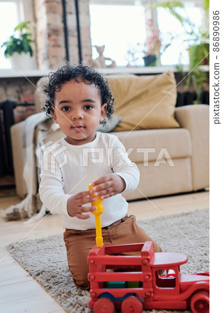 Mixed race boy repairing toy car 86890986