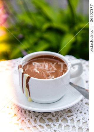 Hot chocolate cup on table at cafe outdoors summer. Coffee time and breakfast in restaurant. Chocolate, hot frothed milk, cocoa. 86892577