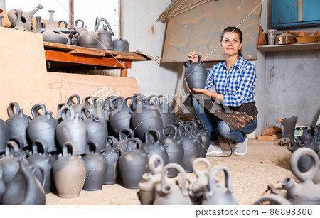 Woman showing finished black ceramic bottle Woman showing finished black ceramic bottle 86893300