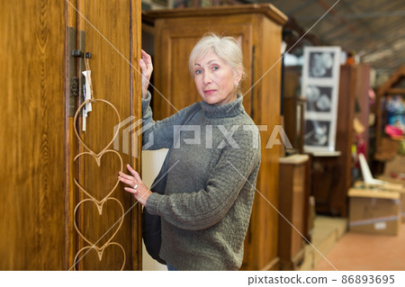 Senior woman choosing closet in furniture store 86893695