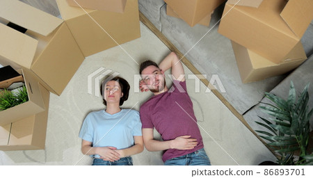 Happy married people buy a new apartment to start new life together. Relocating, new home and people concept. Top view. Happy married people buy a new apartment to start new life together. Relocating, new home and people concept. Top view. 86893701