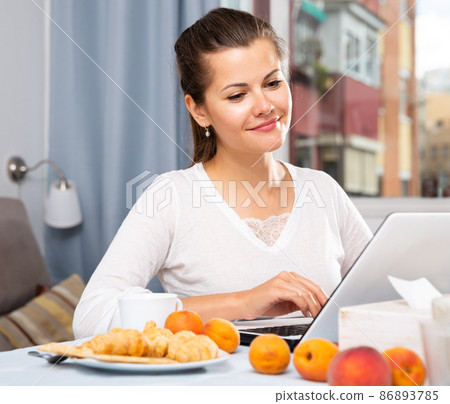 Woman sitting at table with peaches and cup of tea in the morning Woman sitting at table with peaches and cup of tea in the morning 86893785