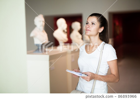 Woman observing sculptures exposition in art museum Woman observing sculptures exposition in art museum 86893966