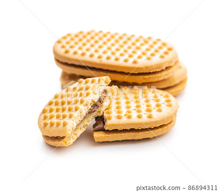 Sweet sandvich cookies. Biscuits with cocoa cream filling isolated on white background. 86894311