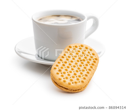 Sweet sandvich cookies and coffee cup. Biscuits with cocoa cream filling isolated on white background. Sweet sandvich cookies and coffee cup. Biscuits with cocoa cream filling isolated on white background. 86894314
