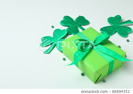 Clover leaves, gift box and beads on white background 86894352