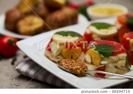 Portion of delicious chicken aspic on a plate isolated on concrete table Portion of delicious chicken aspic on a plate isolated on concrete table 86894719