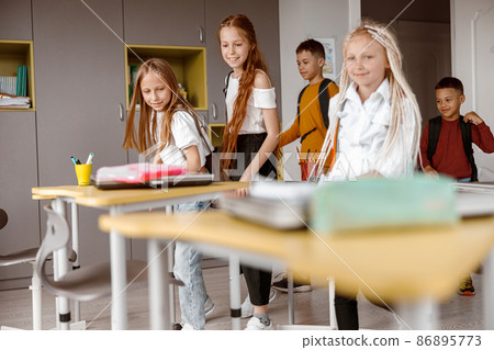 Happy schoolchildren with backpacks entering the classroom 86895773