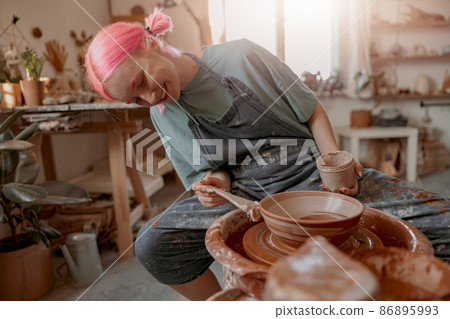 Woman crafter making clay dishes in pottery room Woman crafter making clay dishes in pottery room 86895993