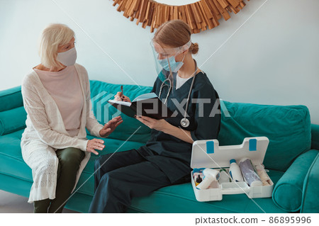 Young female doctor conducting medical consultation at home Young female doctor conducting medical consultation at home 86895996