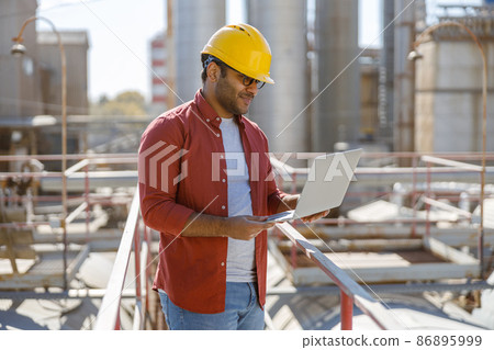 Young industrial engineer with using laptop at plant Young industrial engineer with using laptop at plant 86895999