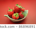 Red strawberries in a bowl. on red background 86896891
