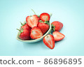 Top view of one and a half strawberry in a small cup on isolated pastel background 86896895