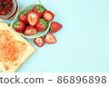 Top view of toast strawberries and jam on isolated pastel background with copy space. 86896898