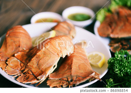 Fresh slipper lobster flathead boiled cooking with parsley rosemary in the seafood restaurant, Flathead lobster shrimps served on white plate and seafood sauce, Rock Lobster Moreton Bay Bug 86898854