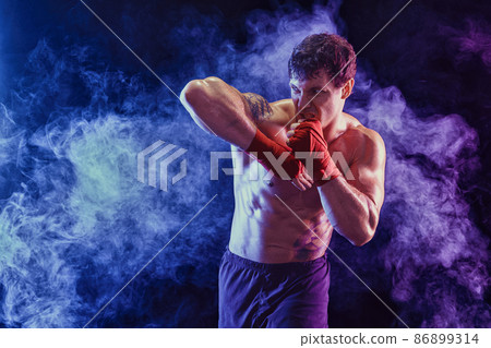 Kickboxer delivering elbow hit isolated on smoke background. Concept of sport, mixed martial arts.  86899314
