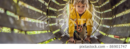 Little boy in a rope park. Active physical recreation of the child in the fresh air in the park. Training for children BANNER, LONG FORMAT Little boy in a rope park. Active physical recreation of the child in the fresh air in the park. Training for children BANNER, LONG FORMAT 86901747
