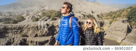 BANNER, LONG FORMAT Young couple man and woman visit the Bromo volcano at the Tengger Semeru National Park on the Java Island, Indonesia. They enjoy magnificent view on the Bromo or Gunung Bromo on BANNER, LONG FORMAT Young couple man and woman visit the Bromo volcano at the Tengger Semeru National Park on the Java Island, Indonesia. They enjoy magnificent view on the Bromo or Gunung Bromo on 86901807