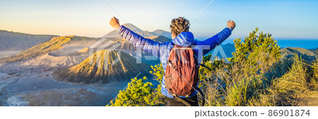 BANNER, LONG FORMAT Young man meets the sunrise at the Bromo Tengger Semeru National Park on the Java Island, Indonesia. He enjoys magnificent view on the Bromo or Gunung Bromo on Indonesian, Semeru BANNER, LONG FORMAT Young man meets the sunrise at the Bromo Tengger Semeru National Park on the Java Island, Indonesia. He enjoys magnificent view on the Bromo or Gunung Bromo on Indonesian, Semeru 86901874