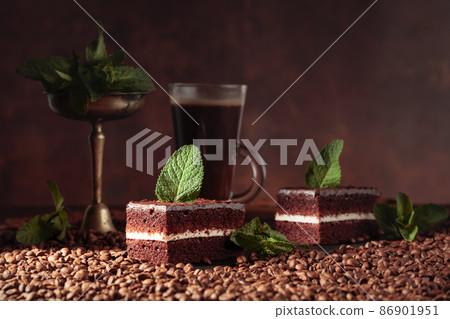 Chocolate cake on a table with coffee beans. Chocolate cake on a table with coffee beans. 86901951