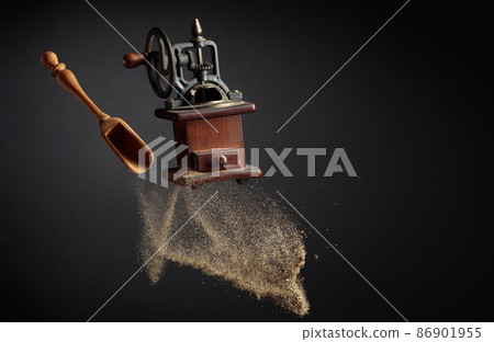 Old pepper grinder and a wooden spoon with pepper ground. Old pepper grinder and a wooden spoon with pepper ground. 86901955