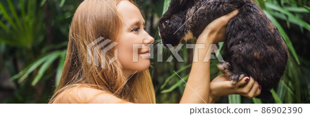 Woman holding a rabbit. Cosmetics test on rabbit animal. Cruelty free and stop animal abuse concept BANNER, LONG FORMAT 86902390