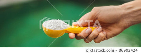 Hand holding Chlorinefor water in the pool BANNER, LONG FORMAT 86902424