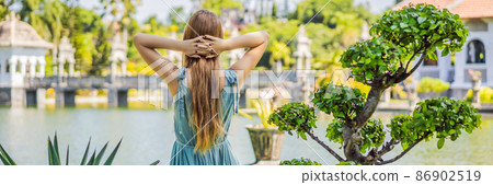 Young woman in dress in Water Palace Soekasada Taman Ujung Ruins on Bali Island in Indonesia. Amazing old architecture. Travel and holidays background BANNER, LONG FORMAT 86902519