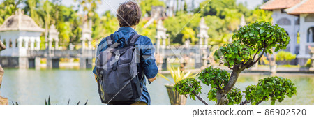 Young man in Water Palace Soekasada Taman Ujung Ruins on Bali Island in Indonesia. Amazing old architecture. Travel and holidays background BANNER, LONG FORMAT 86902520