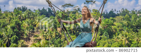 Young woman swinging in the jungle rainforest of Bali island, Indonesia. Swing in the tropics. Swings - trend of Bali BANNER, LONG FORMAT Young woman swinging in the jungle rainforest of Bali island, Indonesia. Swing in the tropics. Swings - trend of Bali BANNER, LONG FORMAT 86902715
