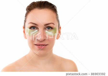 portrait of a young woman taking care of her face, patches against bags under the eyes 86903392