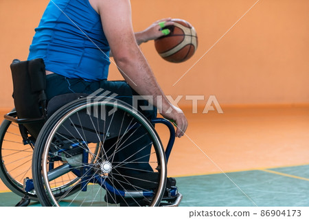 Close-up of sportsman with disability sitting in wheelchair playing basketball 86904173